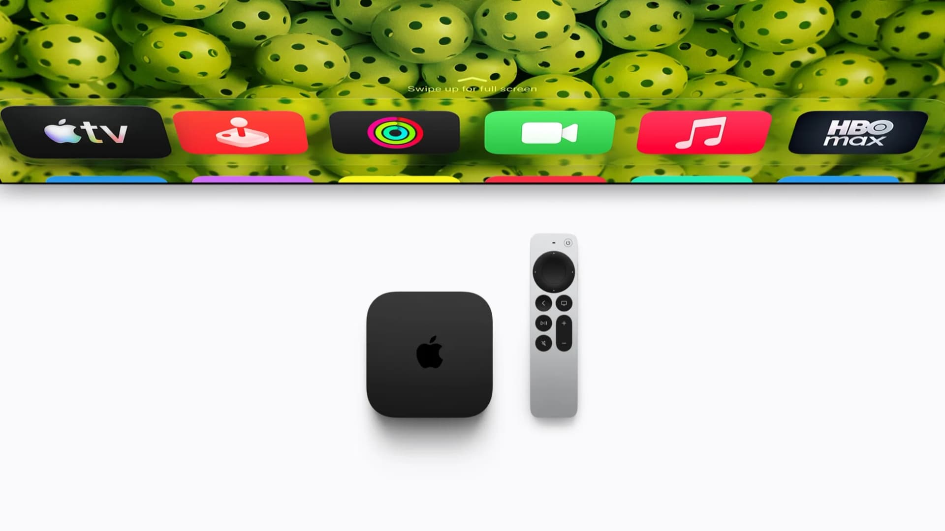 Apple TV 4K 2026 modeli ve Siri Remote kumandası, arkada televizyon ekranı